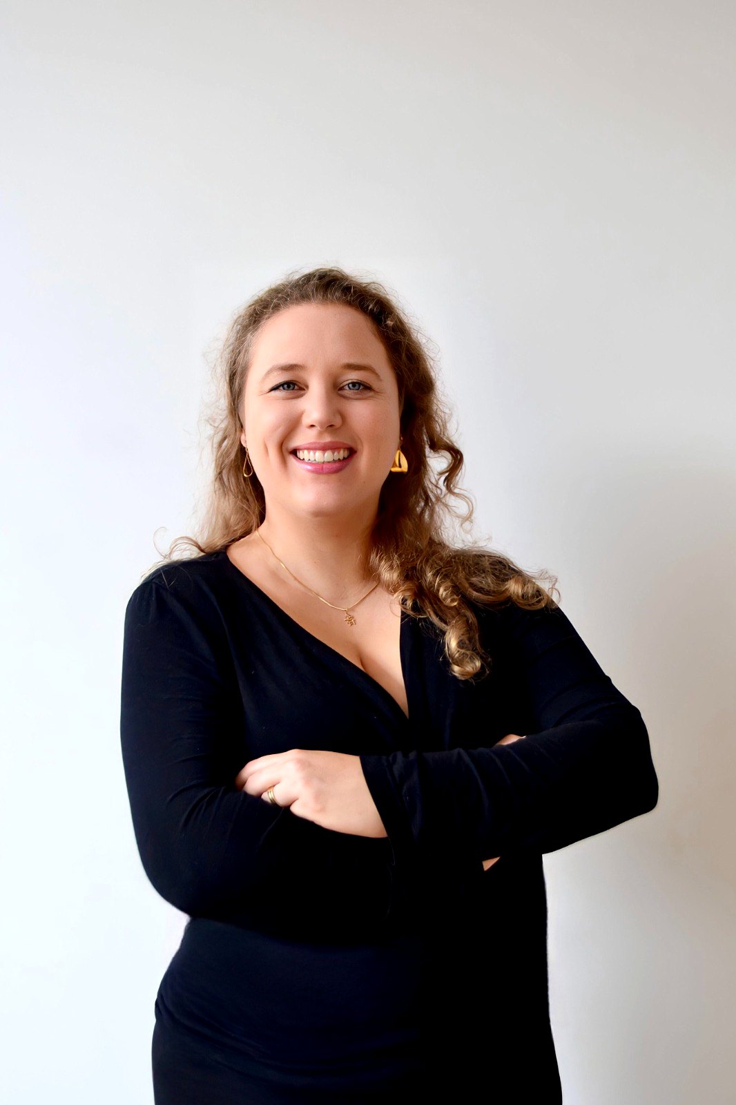 Alícia Keller Felsky de braços cruzados, sorrindo